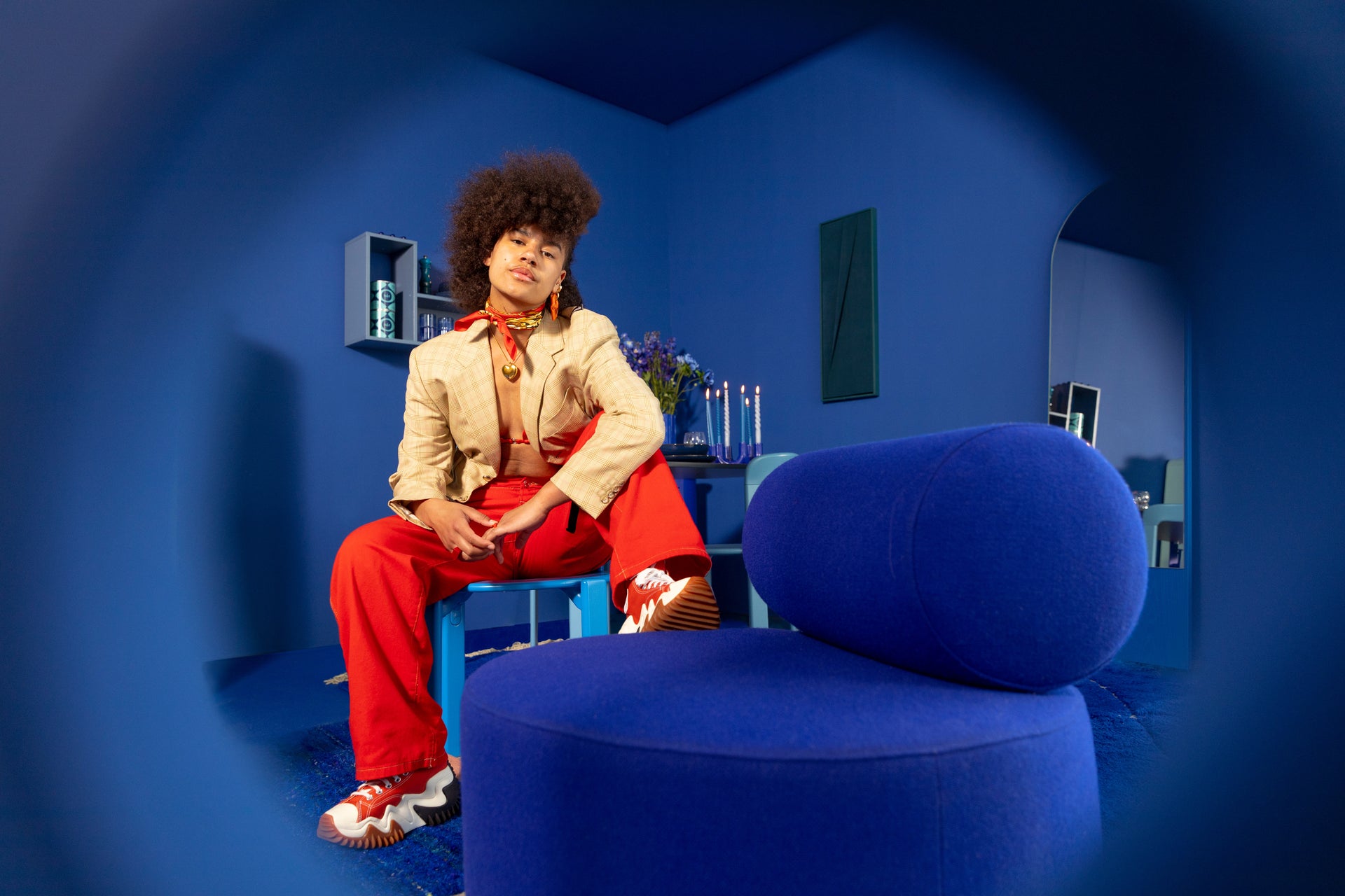 Een man in een blauw interieur met een ronde fauteuil