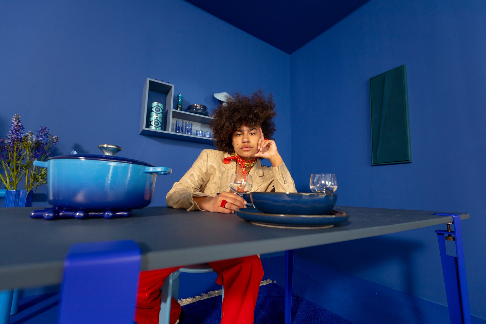 Een man aan tafel in een diepblauwe kamer